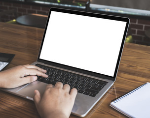 Empty white screen laptop computer on wooden table top, business concept, Notebook mockup design with copy space for text and advertising.