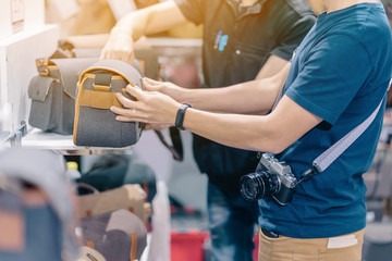 Male photographer choose camera bag that is suitable for the size of the camera used in photoghaphic store.