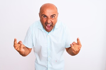 Naklejka premium Middle age handsome man wearing casual shirt standing over isolated white background shouting with crazy expression doing rock symbol with hands up. Music star. Heavy concept.