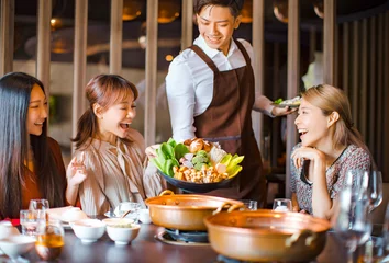 Schilderijen op glas waiter  bring  vegetables for hot pot  and serving group of friends in restaurant © Tom Wang