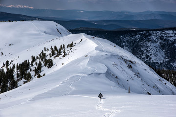 Irkutsk region, Russia, Slyudyanka - April 13, 2019: Silhouette of man are hiking in the mountain and snow back view