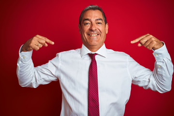 Handsome middle age businessman standing over isolated red background looking confident with smile...