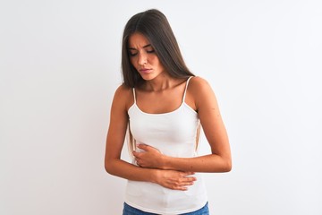 Young beautiful woman wearing casual t-shirt standing over isolated white background with hand on stomach because nausea, painful disease feeling unwell. Ache concept.