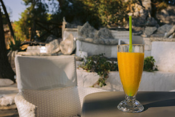 glass of fresh orange juice on the table in summer cafe