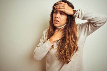 Naklejka premium Young beautiful woman wearing winter sweater standing over white isolated background Touching forehead for illness and fever, flu and cold, virus sick