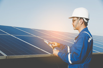 industrial concept; engineer in blue uniform working on repairing generating power of solar power plant