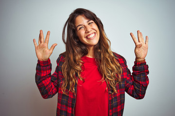 Young beautiful woman wearing red t-shirt and jacket standing over white isolated background showing and pointing up with fingers number nine while smiling confident and happy.
