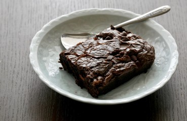 青いお皿にのせられたチョコレートブラウニー、スプーン