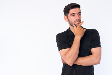 Portrait of young bearded Persian man thinking and looking up