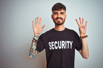 Young safeguard man with tattoo wering security uniform over isolated white background showing and...
