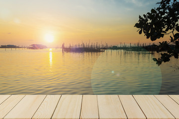 Fototapeta na wymiar sunset over lake and wood terrace in the evening,well use editing display products on 