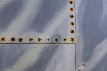 Texture of old jet plane with tiger camouflage and rusty screw