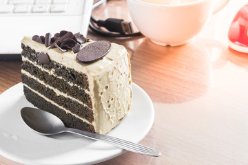 dark chocolate cake and white coffee cup on desk