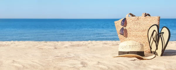 Tuinposter Stylish beach accessories on sandy sea shore. Banner design © New Africa