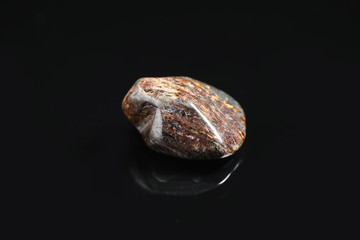 Beautiful brown bronzite gemstone on black background