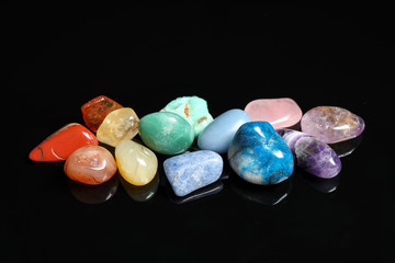 Pile of different beautiful gemstones on black background