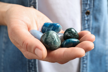 Young woman holding many beautiful gemstones, closeup