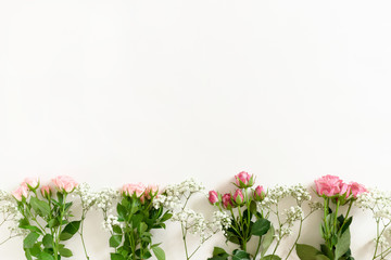 Border frame made from gypsophila, pink eustoma flowers and green leaves