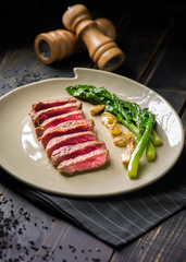 Sliced medium rare Roast beef  on dark background in lighting studio