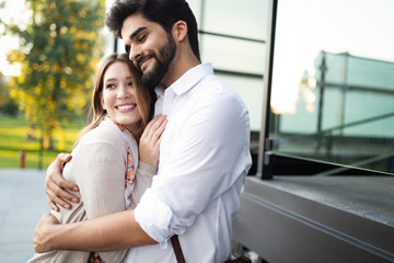 Happy young couple hugging and laughing outside