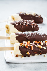 Vegan dessert for kids. Banana in dark chocolate with nuts.