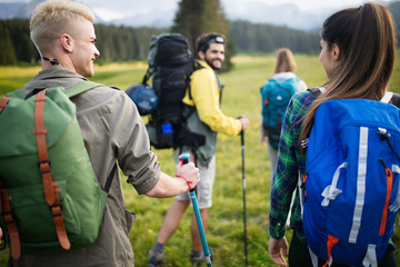 Group of young friends hiking in countryside. Multiracial young people on country walk.