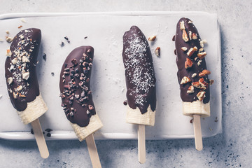 Vegan dessert for kids. Banana in dark chocolate with nuts.