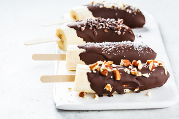 Vegan dessert for kids. Banana in dark chocolate with nuts.
