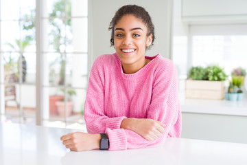 Beautiful african american woman with afro hair wearing casual pink sweater with a happy and cool smile on face. Lucky person.