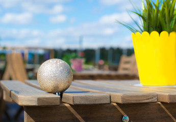 Christmas toy on a table in the open air. Festive background. Festive New Year mood. Christmas in a southern country. Festive background.