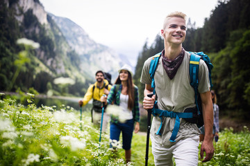 Fototapeta na wymiar Group of happy friends with backpacks hiking together