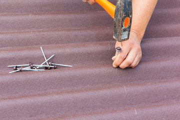 Roofer installs asphalt shingles Ondulin, roof repair.