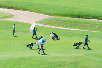 A group of people with golf attributes go to the golf course.