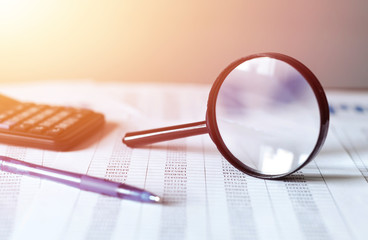 Single Magnifying Glass with Black Handle, Leaning on the financial data. Business and Finance...