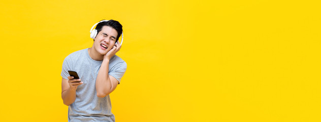 Asian man wearing headphones and singing while listening to rock music