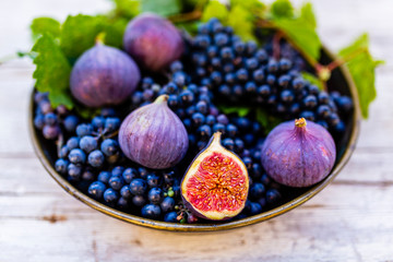 Ripe grapes and figs on an vintage plate.