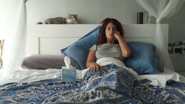 a woman sick with flu or cold in her bed