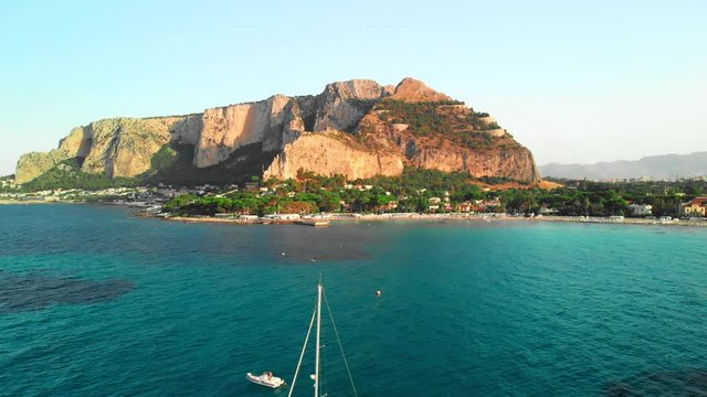 Sailing boats on a roadstead near a paradise tropical island. Pre-sunset time. Aerial drone shot.