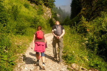 Naklejka na ściany i meble tourists wandering in the mountain gorge