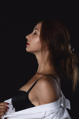 Fototapeta premium attractive beautiful athletic girl model in black underwear and white shirt sitting isolated on black background in photo studio