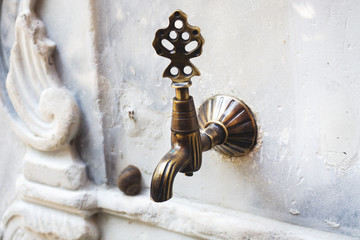 Turkish Ottoman style vintage water tap at the fountain of ablution in the yard.