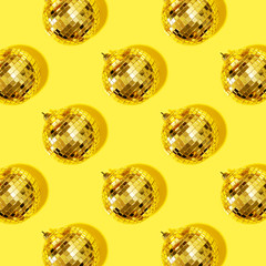 New year baubles. Shiny gold disco balls on yellow background. Pop disco style attributes, retro concept. Creative Christmas pattern. Flat lay, top view.