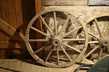 Fototapeta na wymiar Old wooden wheels from grandfather's cart are stored in a rustic barn