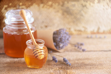 Herbal honey with lavender flowers, bee pollen granules, honey conb on grey background. Autumn harvest concept