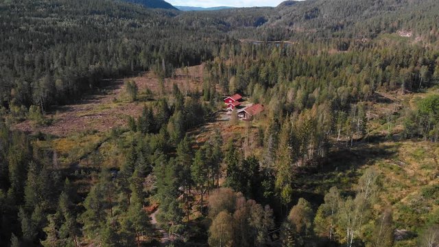 Aerial view over Heisetra cabins with a beautiful lake and lots of pine trees and forest surrounding the cabins, in Kodal, Norway