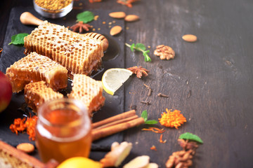 Autumn picnic. Herbal tea, honey and bee products, apple, lemon, calendula, spices on dark...