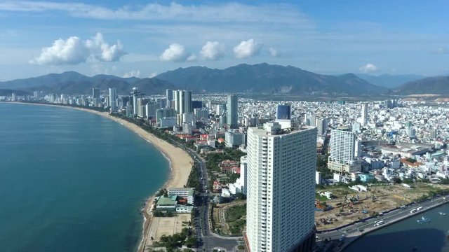 Aerial Drone Footage Of The Beautiful Bay Of Nha Trang, Drone Is Moving Backwards And Up Delivering Nice Architecture Of The City With Moutains In Background