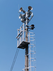 Low angle view of Emergency siren against blue sky background.