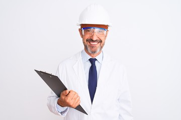 Senior engineer man wearing helmet glasses holding clipboard over isolated white background with a happy face standing and smiling with a confident smile showing teeth