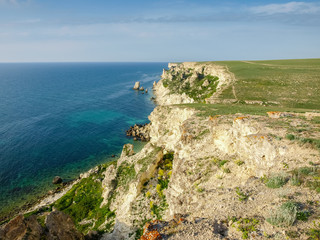 Fototapeta na wymiar Section of sea coast with steep textured limestone rocks